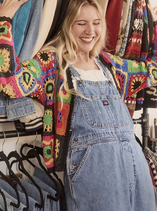 model wears denim overalls