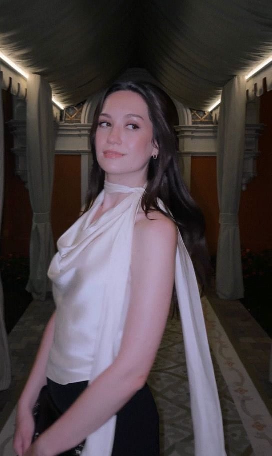 Aleksandra wearing a white scarf top at night