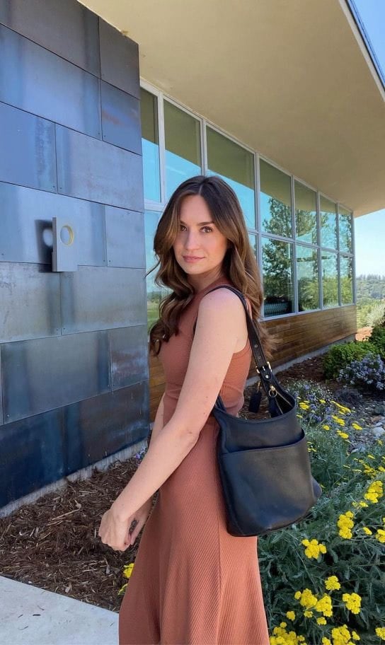 Aleksandra wearing a peach dress outside a blue building