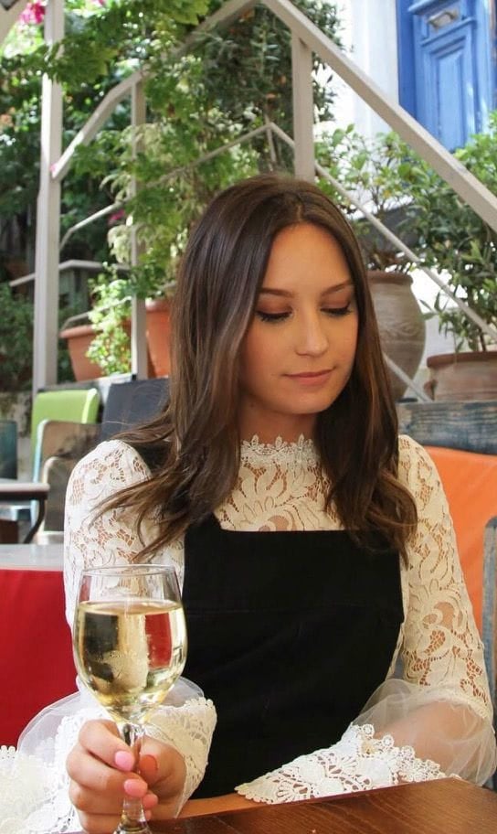 Aleksandra wearing a lace top at an outdoor table