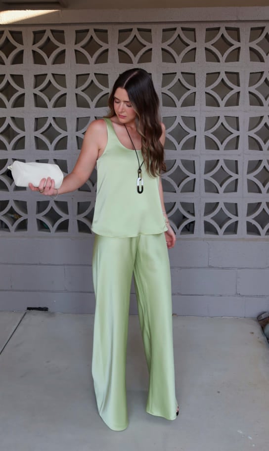 Maddy wearing a sage green satin tank and matching wide-leg pants