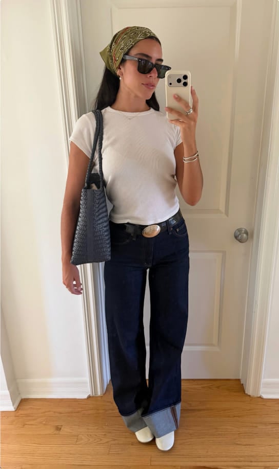 Ceci in a white t-shirt and dark wide-leg jeans with a green bandana