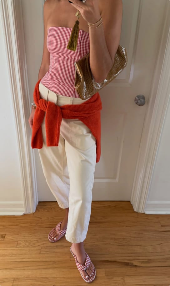 Ceci in a red gingham top with an orange cardigan tied at the waist