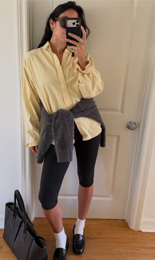 Ceci in a yellow button-down shirt tied over black bike shorts