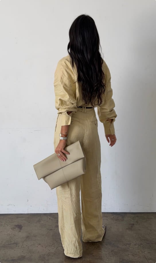 Ceci in a yellow shirt and matching wide-leg trousers, back view